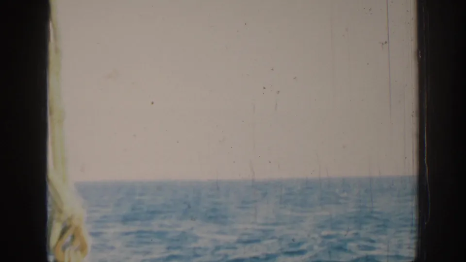 1962 Rhodes, Greece home-movie frame showing a knotted rope and rigging beside open Mediterranean water.