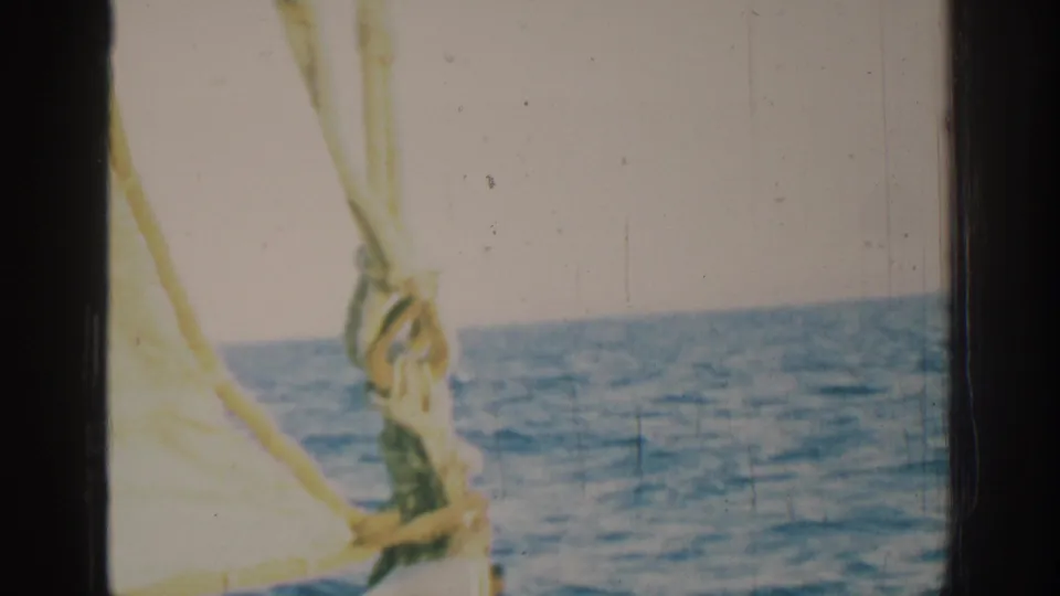 1962 8mm sailing footage near Rhodes, Greece, with foreground rigging and a rope knot against the open Mediterranean water.