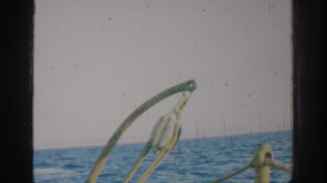 Open water and sky with curved metal boat hardware in the foreground.