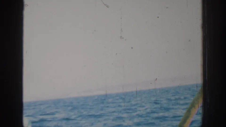 1962 Rhodes, Greece 8mm frame of open sea and sky, with a small section of boat hardware visible at the right edge.