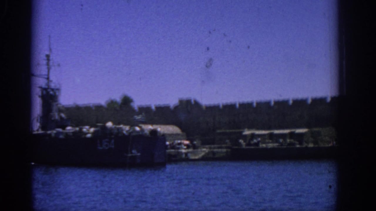 Harbor vessel and dock structures seen through dark film-frame edges.