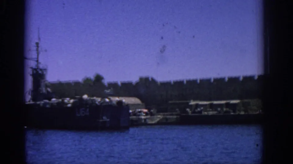 Rhodes harbor scene with a military ship, dock equipment, and stone wall visible through 8mm frame vignetting.