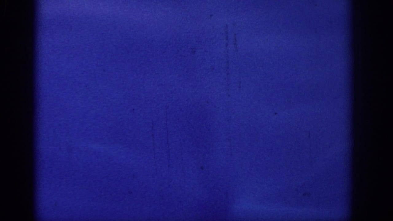 Mostly blue film frame with black vertical edges and faint surface marks.