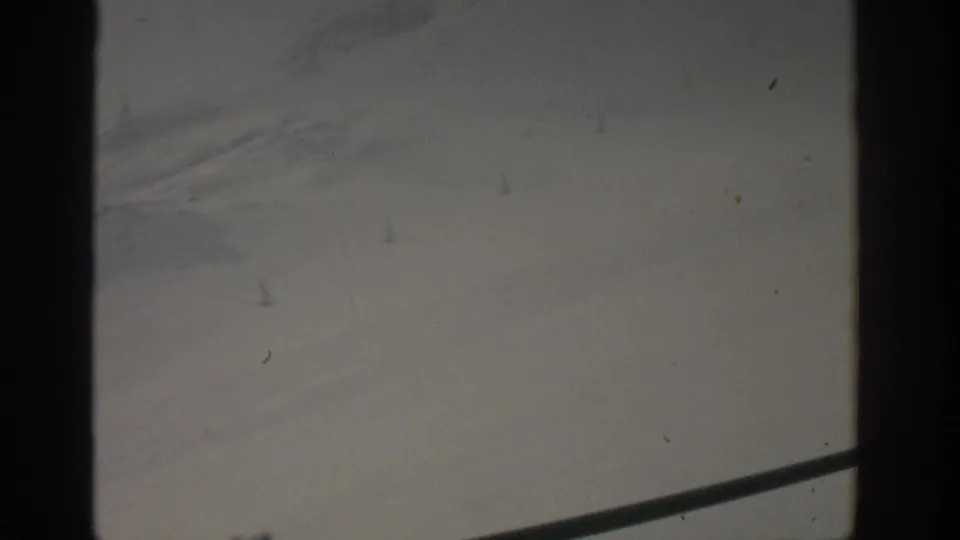 A dim 1963 Munich window view with a central dark mullion, pale gray background, diagonal lower line, and visible 8mm dust specks.