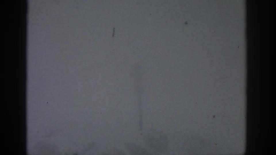 1963 Munich-attributed 8mm frame with a dark central pole or structure seen through dense gray fog.