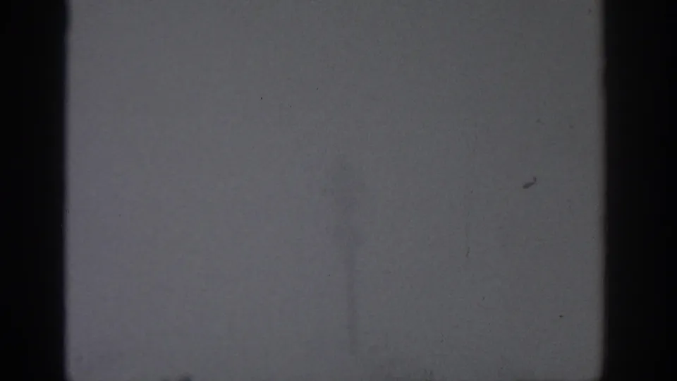 1963 Munich-attributed 8mm frame of a fog-filled outdoor view with a dark edge and indistinct vertical form beyond.