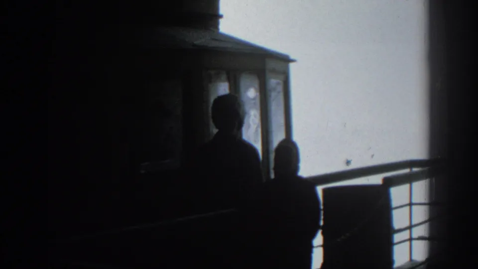 Silhouetted figures remain inside the Munich tram cab, partly outlined by window light and the exterior railing.