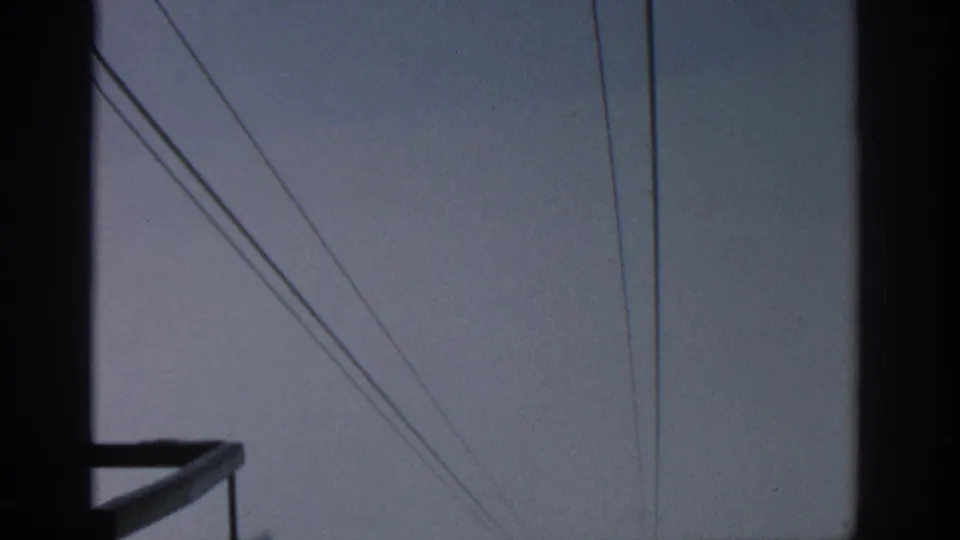 Munich 1963 utility view with dark structural framing, a bracket-like platform, and overhead lines in muted light.