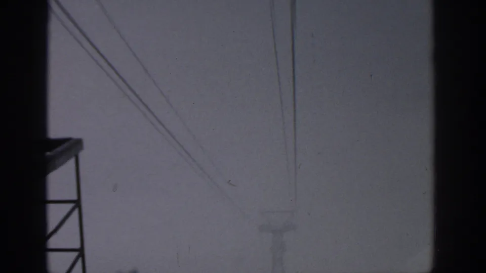 1963 Munich frame with diagonal wires, a faint distant transmission tower, and dark window-like edges.