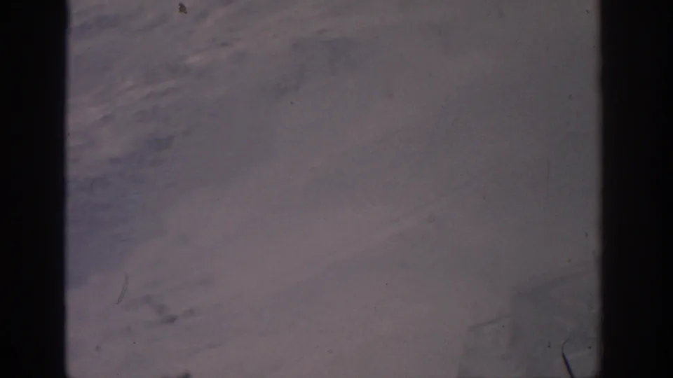 The cable-car view continues over pale snowfields, with heavy interior frame shadows and visible 8mm dust marks.