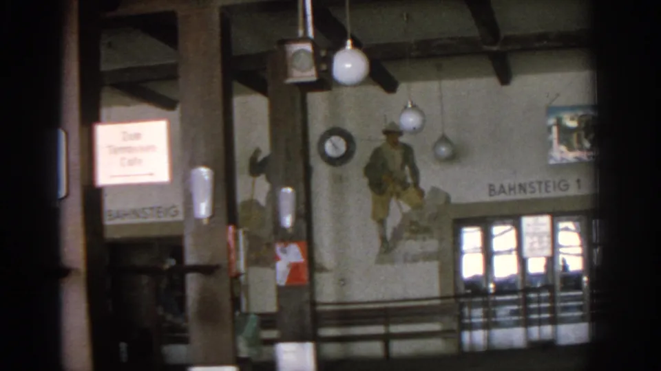 1963 Munich interior showing timber beams, globe lamps, a wall mural, a Zum Tennessee Cafe sign, and Bahnsteig 1 lettering.