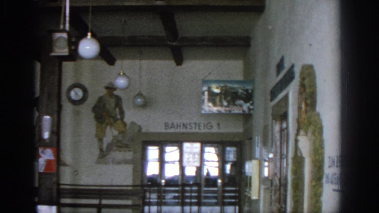 Station wall with soldier mural, Bahnsteig 1 sign, clock, lights, glass doors, and right-side mural.