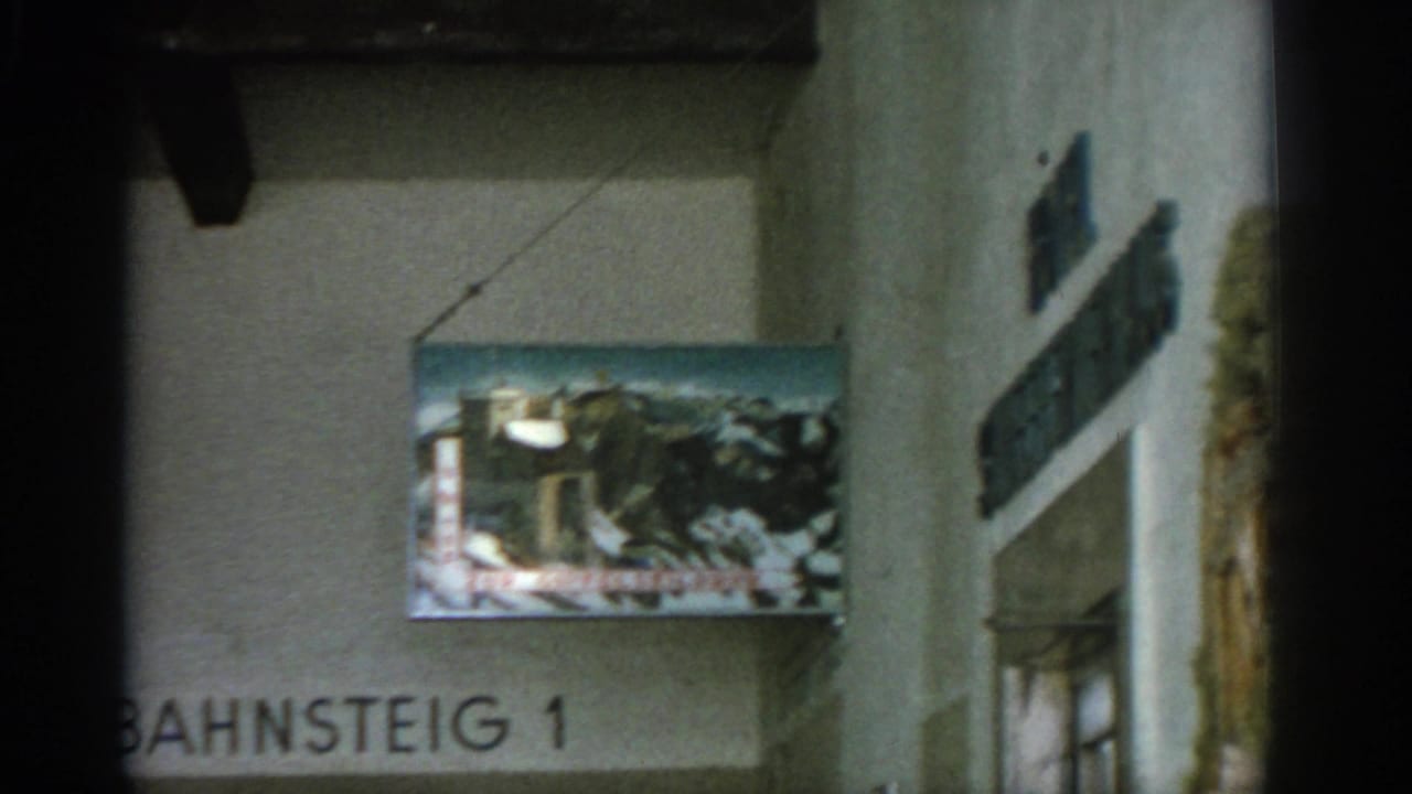Hanging painted mountain sign beside Bahnsteig 1 lettering on an interior wall.
