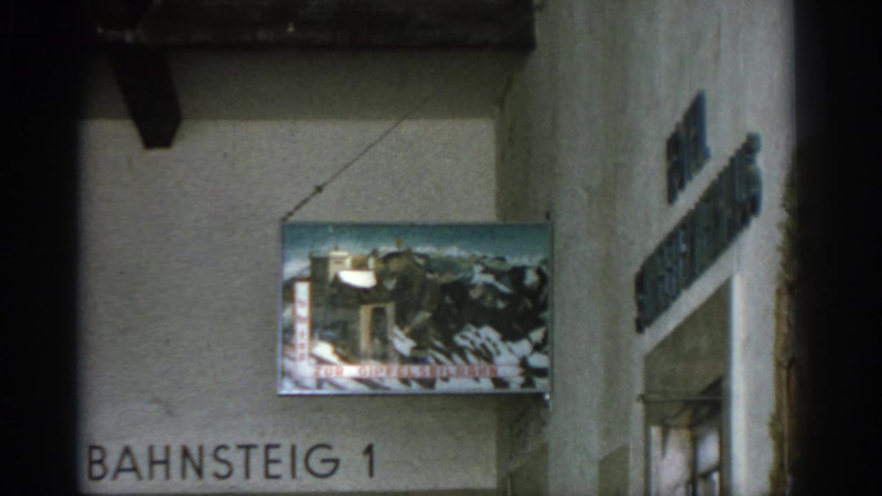 Closer view of the hanging mountain sign and Bahnsteig 1 wall text.