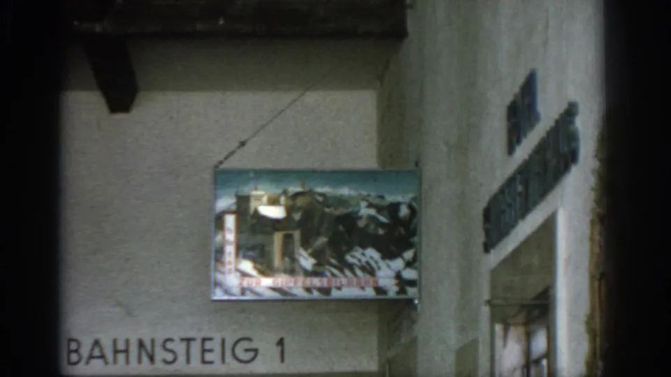 German hotel or station interior detail with painted mountain signage, Bahnsteig 1 lettering, and a partial vertical wall sign.