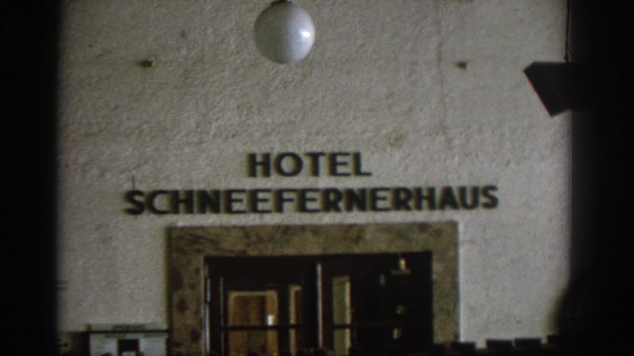 Hotel Schneefernerhaus sign above a dark entrance on a stucco facade.