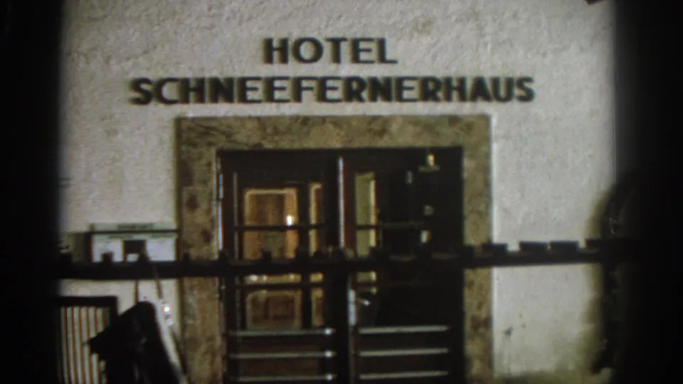 Late frame from the 1963 home movie showing the Hotel Schneefernerhaus sign and dark entrance details in Germany.