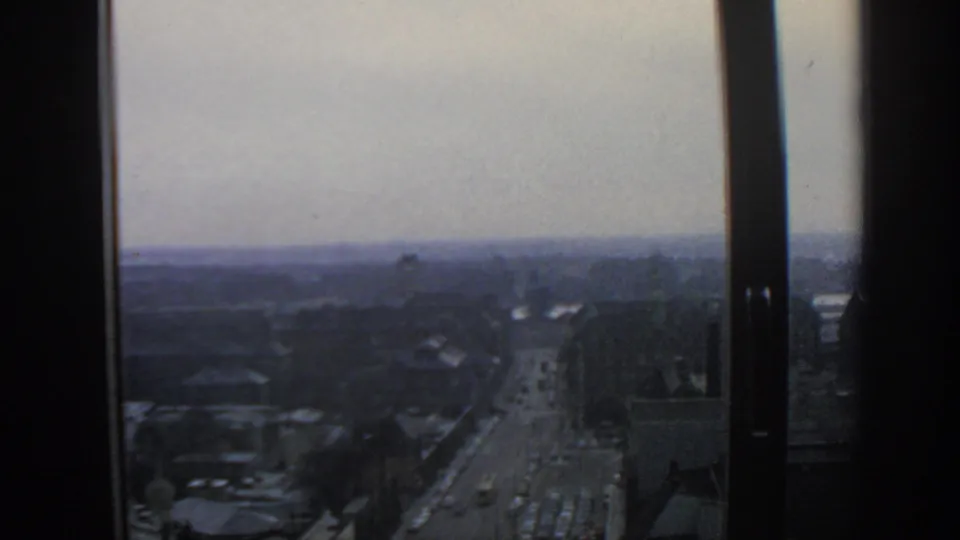 Elevated 1963 Warsaw city view with cars and buses moving along a broad street below.