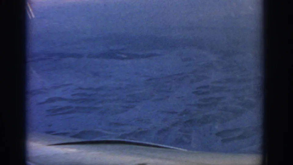 Airplane-window view of a broad snowy landscape, likely near Warsaw in 1963, with blue cast and dark interior framing.