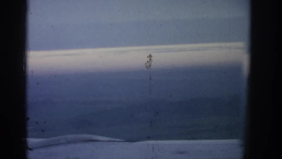 Warsaw-attributed 1963 8mm frame showing a quiet horizon, soft landscape tones, dark borders, and surface wear.