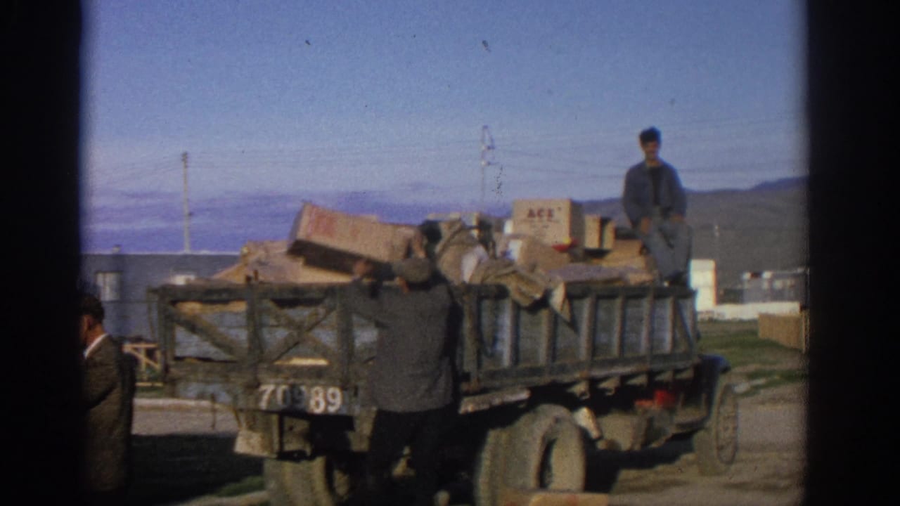 Loaded truck with boxes while men stand and work near the vehicle.