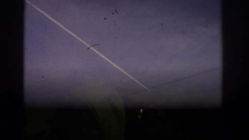 End frame shows the contrail in Zurich sky with utility wires and a dark, indistinct foreground edge entering the shot.