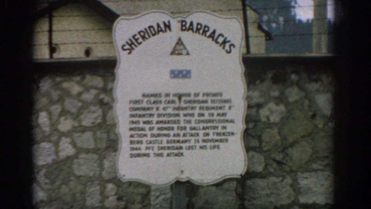 1963 Switzerland 8mm frame showing a Sheridan Barracks memorial plaque on a stone wall with military insignia above the text.