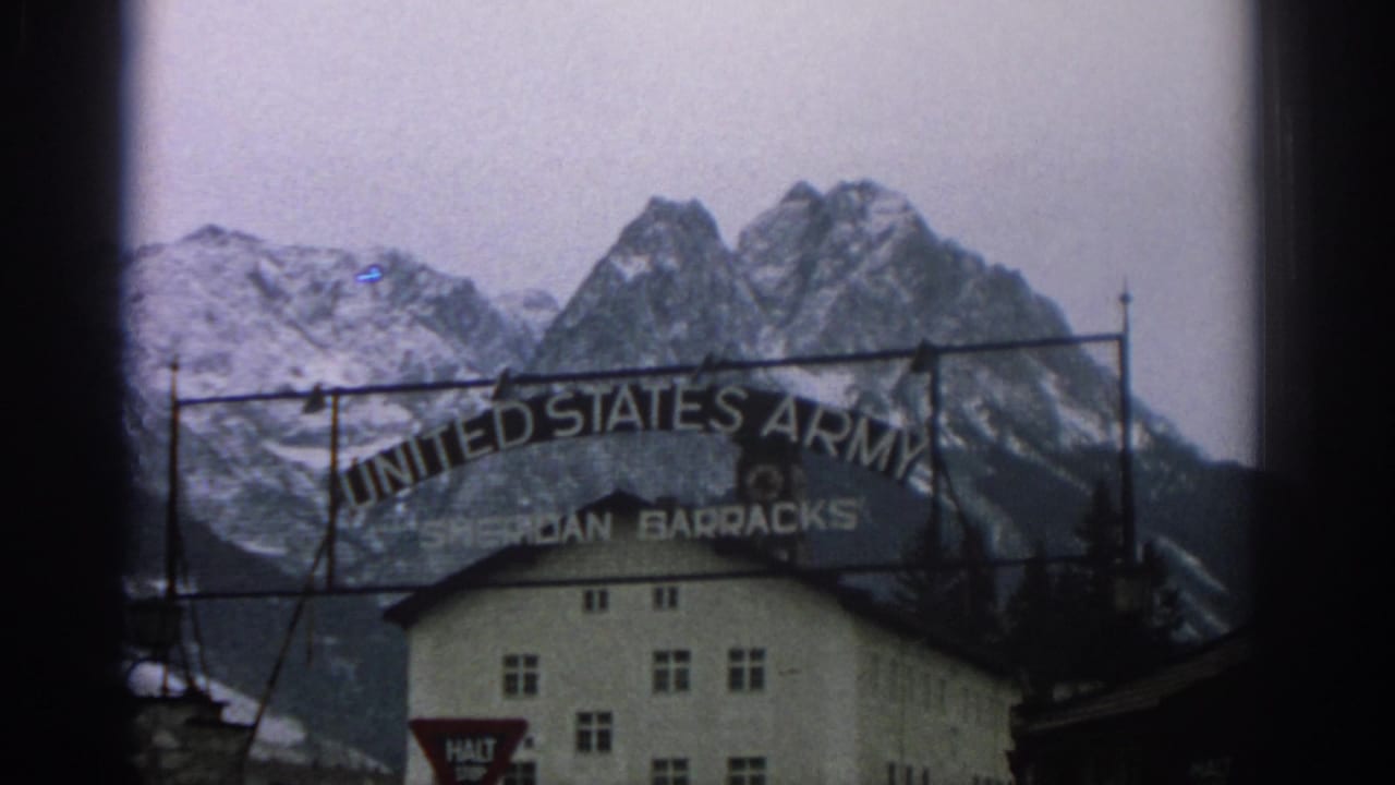 United States Army Sheridan Barracks sign in front of snowy mountains.
