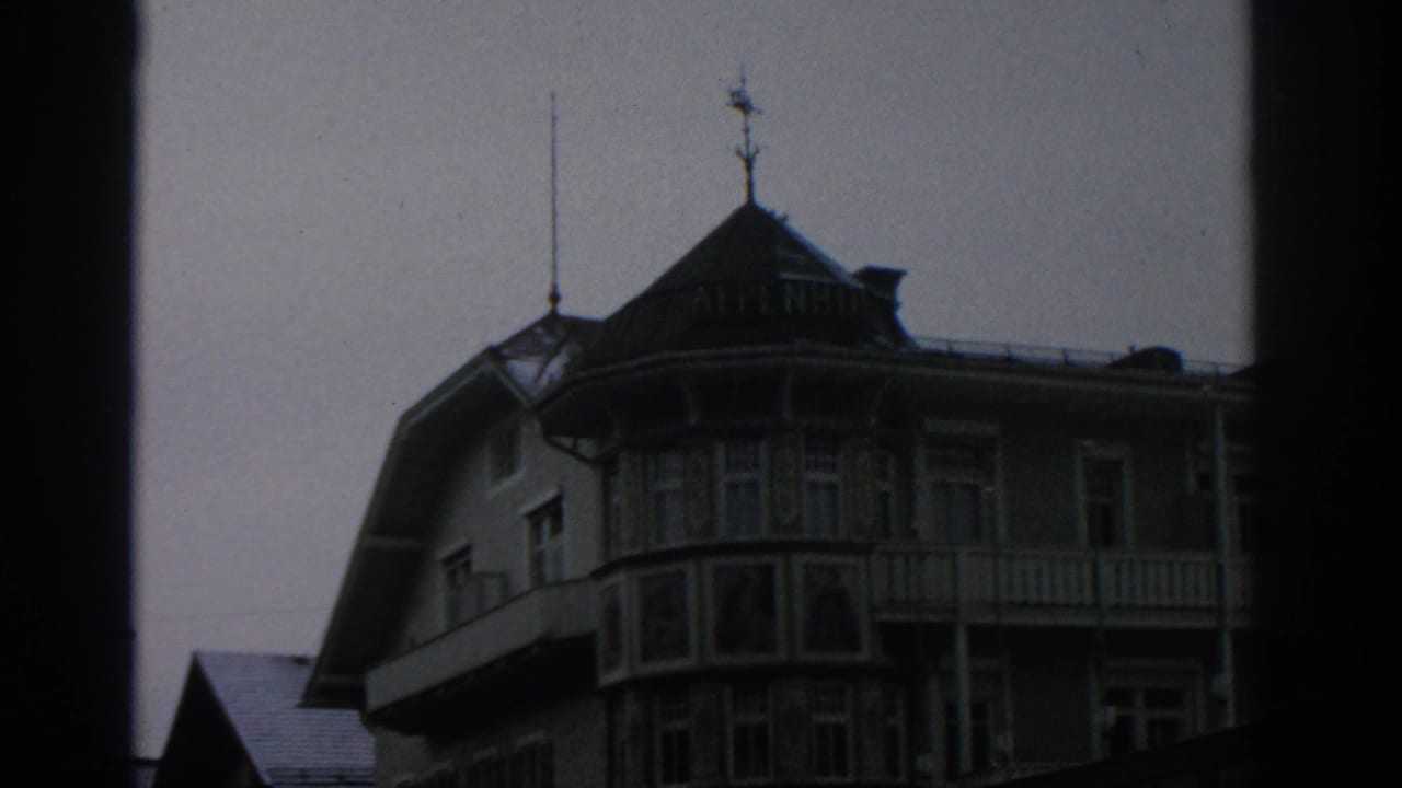 1963 Switzerland travel frame with an alpine-style hotel facade, ornate balcony details, and visible ALPENHOF roof lettering.