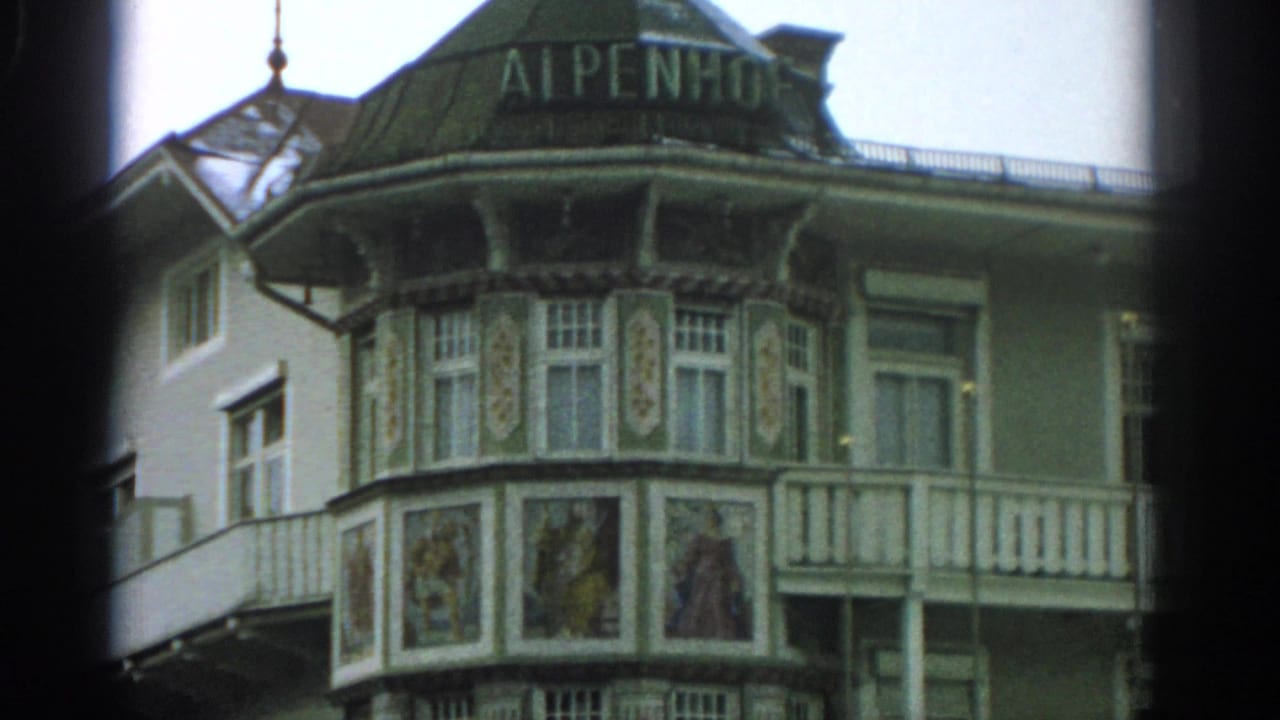 Closer 1963 Zurich view of the ALPENHOF sign over an ornate hotel bay with painted panels and white balcony railing.