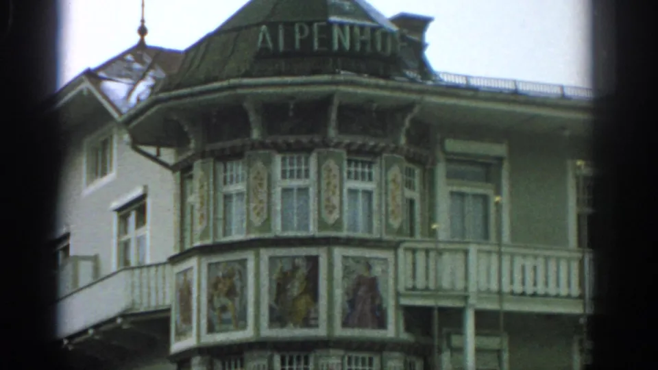 Closer 1963 Zurich view of the ALPENHOF sign over an ornate hotel bay with painted panels and white balcony railing.