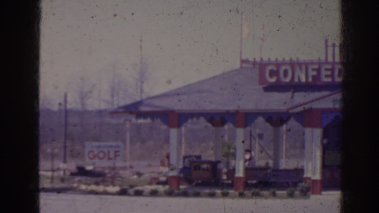Roadside pavilion with cropped CONFEDERATE sign, golf sign, and small train visible under the roof.