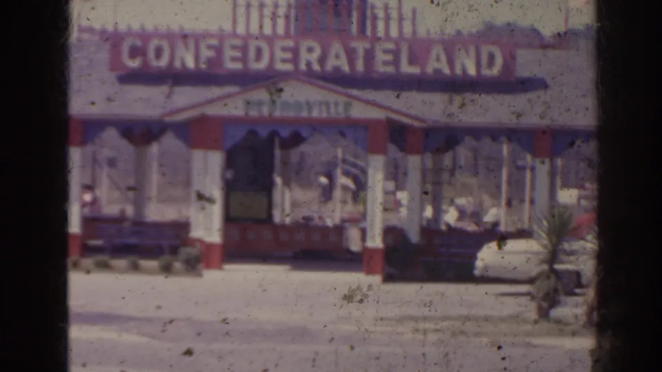 1962 Florida frame of the Confederateland entrance, with the booth, display train, and a person visible near the attraction.