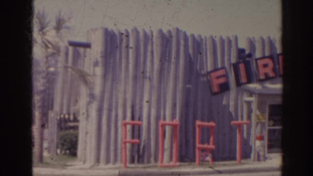 Log-style storefront with partial FIRE lettering, red FORT letters, and a doorway at right.