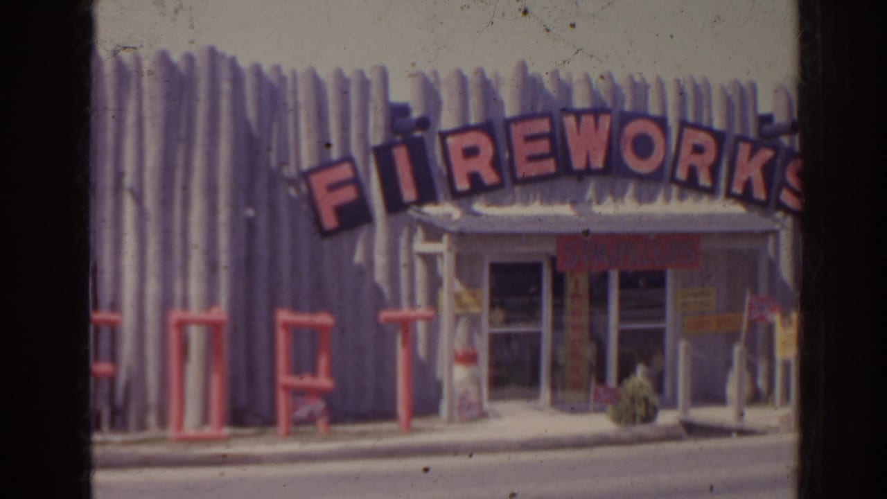 Fireworks storefront with arched red sign, corrugated facade, glass doors, and sidewalk details.