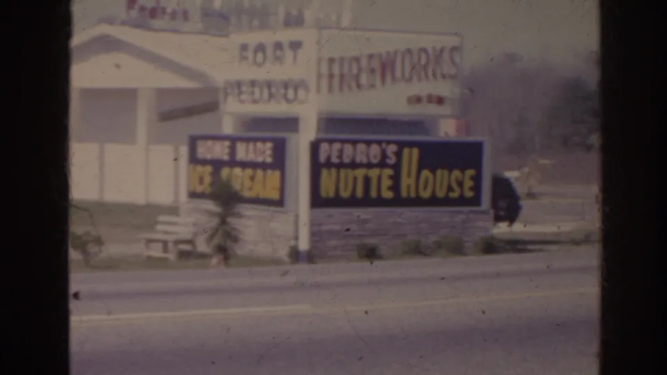 1962 Florida 8mm frame showing Fort Pedro Fireworks and Pedro's Nutte House signs across a paved roadside.