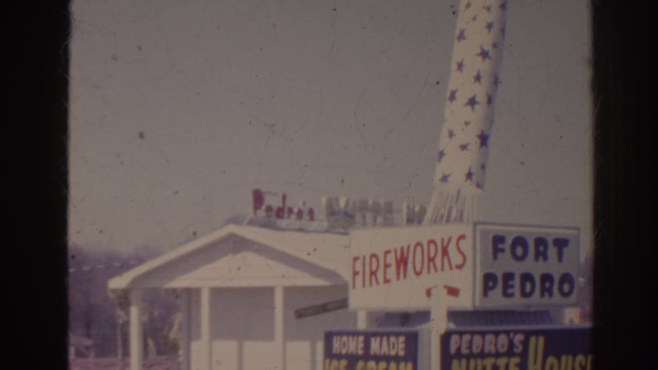 1962 Florida home-movie frame with Fireworks, Fort Pedro, and Pedro's Nutte House signage outside a white roadside building.
