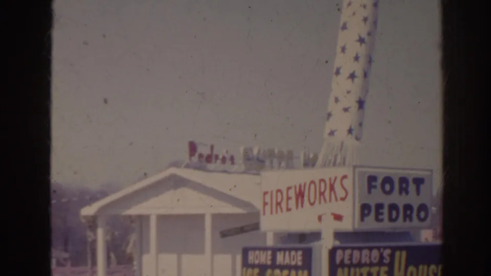 1962 Florida home-movie frame with Fireworks, Fort Pedro, and Pedro's Nutte House signage outside a white roadside building.