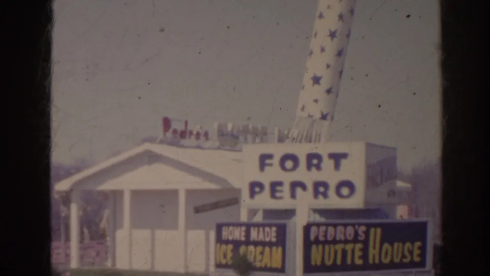 1962 Florida frame showing Fort Pedro, Home Made Ice Cream, and Pedro's Nutte House signs beside a white roadside building.