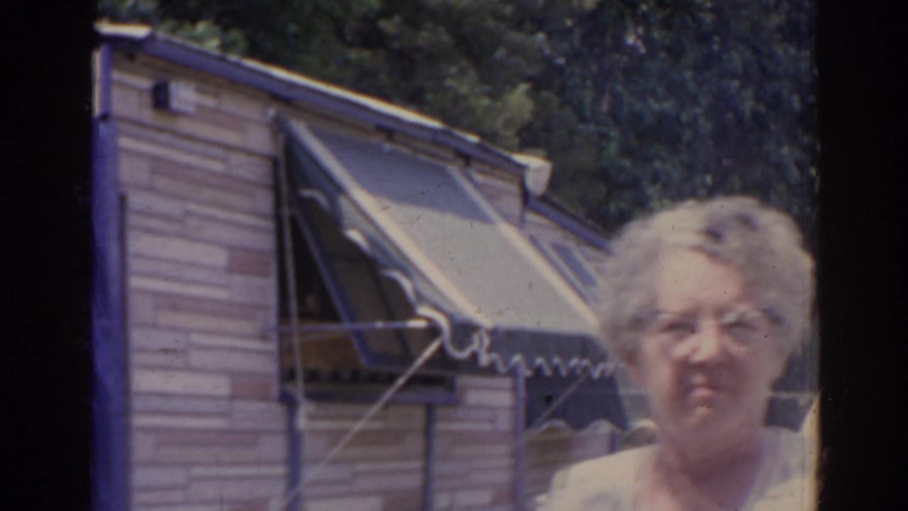 An older woman stands close to the camera beside a striped awning and light exterior wall in the supported Florida backyard setting.