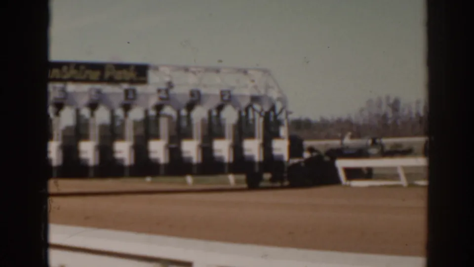 Numbered starting stalls at Sunshine Park racetrack in Florida, filmed from a spectator-side home-movie angle.