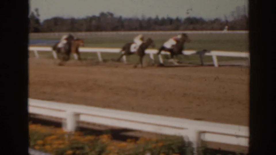 Jockeys ride horses around a Florida dirt racetrack in a soft, handheld 8mm frame from 1962.