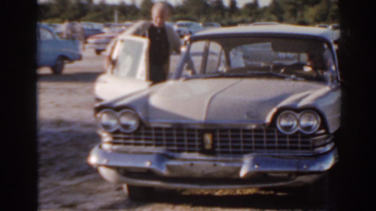 Front view of a classic sedan with a man near the open side door.