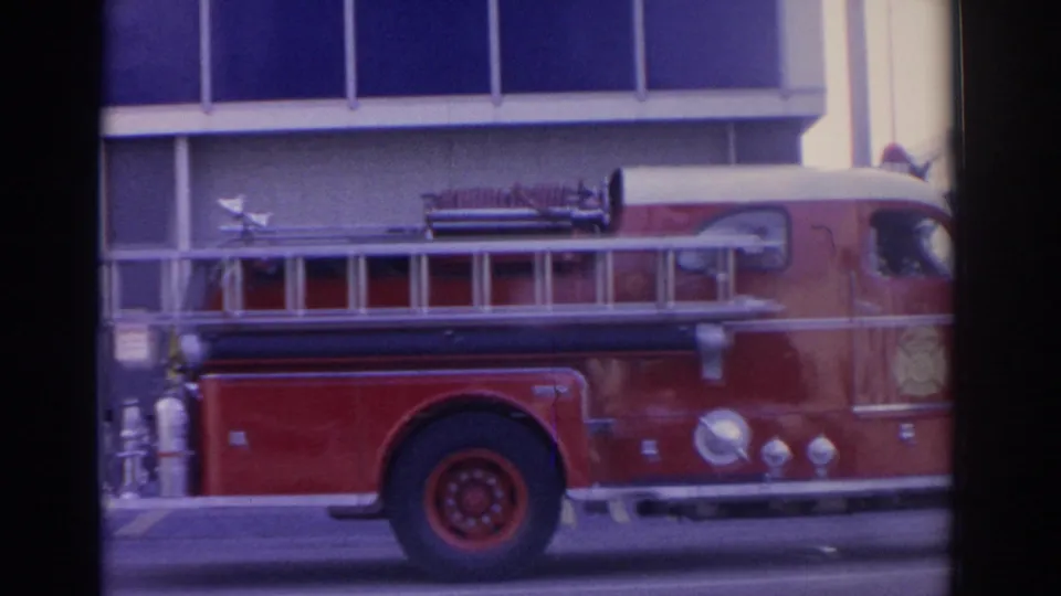 1962 Florida 8mm frame showing a red vintage fire truck parked along a street with ladder and side equipment visible.