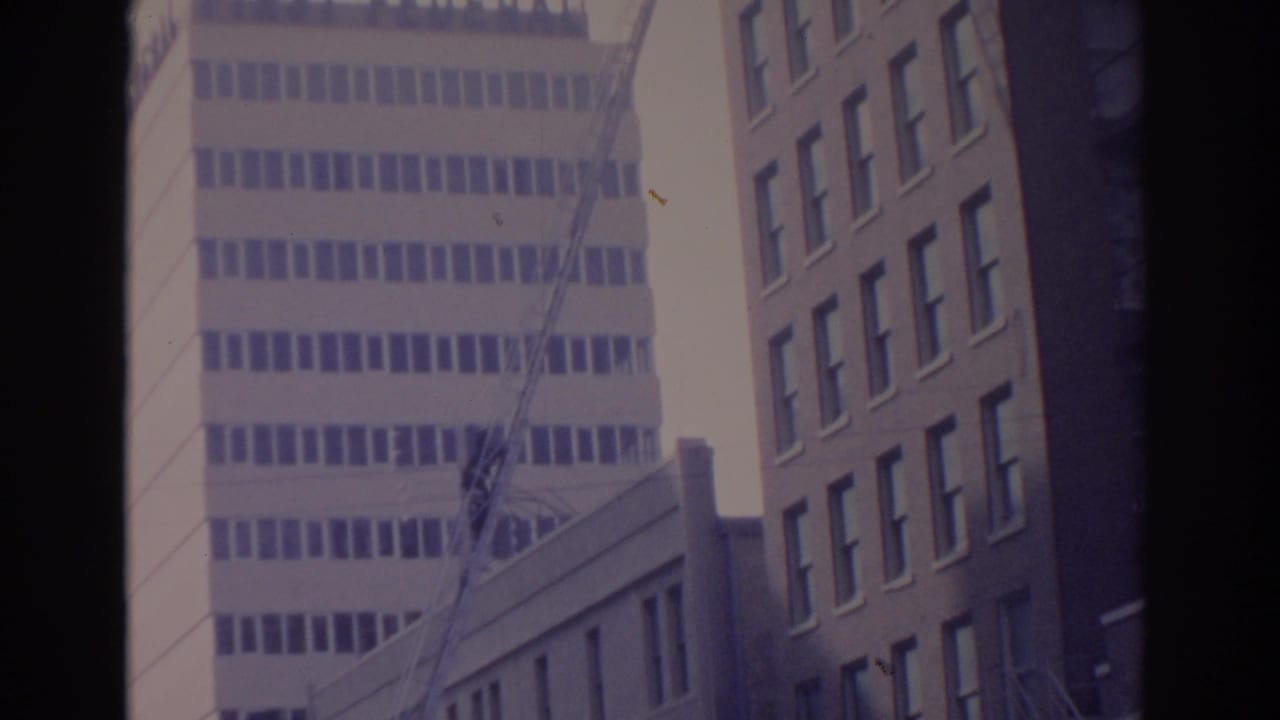 Downtown buildings seen from below with dark film borders.