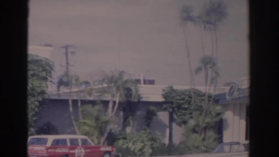 8mm frame with the red news wagon at lower left and the Channel 13 sign partly visible on the building.