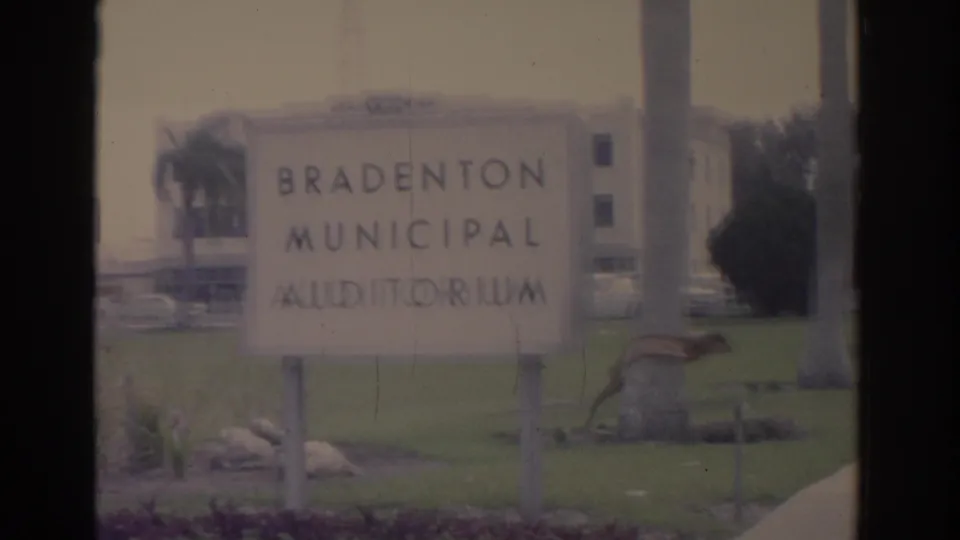 1962 Florida frame with the Bradenton Municipal Auditorium sign in the foreground, lawn and auditorium building visible behind.