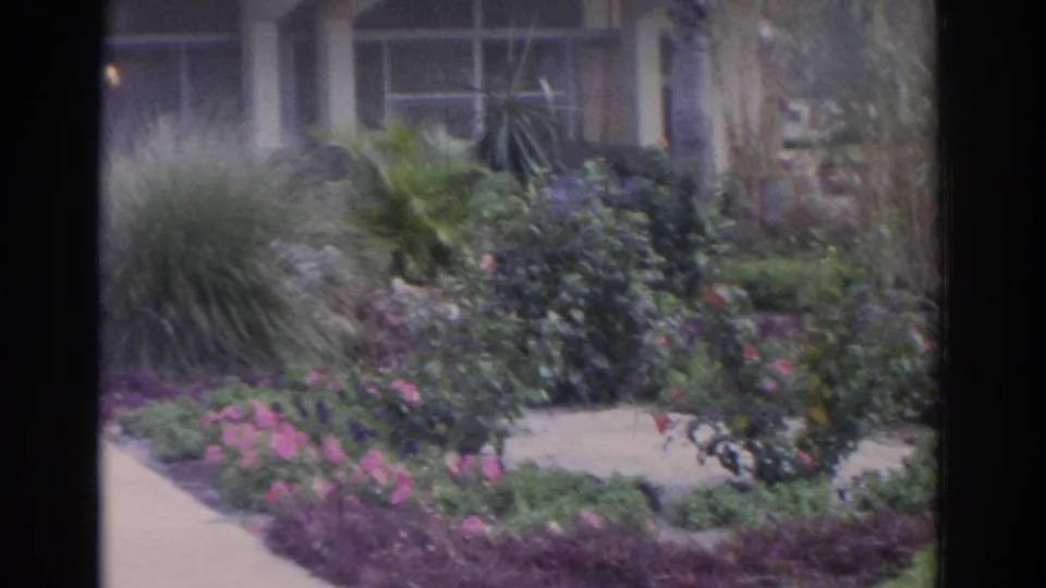 The final frame shows a landscaped garden bed, walkway, and building windows in the 1962 Florida 8mm sequence.