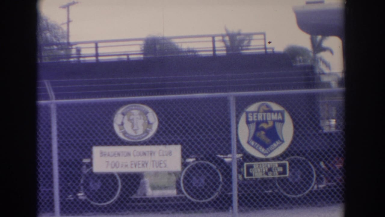 Chain-link fence with Bradenton Country Club and Sertoma signs, bicycle behind the fence.