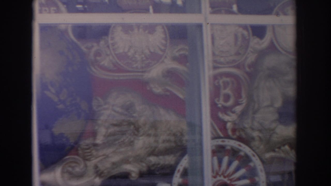 1962 Florida 8mm frame with a dark window edge, partial circus artwork, street reflections, and soft home-movie color.